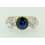 A fine 18 carat gold ring set central sapphire (1.99ct) flanked by two diamonds (85pts each) size O,