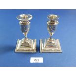 A pair of silver candlesticks of urn form embossed swags, 72cm, London 1906