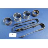 Four silver napkin rings and three pairs of tongs, 184g