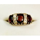 A 9ct gold ring set three garnets and six small white stones, size K-L