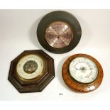 An oak circular barometer, an octagonal one and a slate cased one