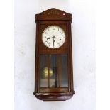 A vintage Westminster chiming eight day wall clock in a wooden case with pendulum and key