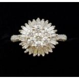 An 18 carat gold diamond cluster ring set seven brilliant cut diamonds in baguette cut surround,