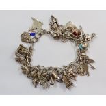 A silver charm bracelet and quantity of silver and white metal charms, 65g