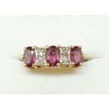 An 18 carat gold ring set three amethysts interspersed by two pairs of diamonds, size I, 4g