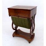 An early 20th century mahogany sewing table with lyre end supports, two drawers over slide out well