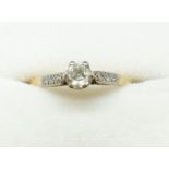 A early 20th century 18ct gold and platinum set solitaire diamond ring on diamond chip shoulders,