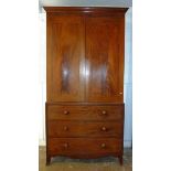 An early 19th century mahogany linen press the arched cornice with inlaid ray motif over two doors