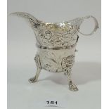 A Georgian Irish silver jug with all over embossed decoration inlcuding dolphin, bird, floral and