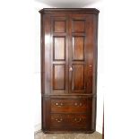 A Georgian large mahogany corner cupboard with panelled doors enclosing shelves over pull out