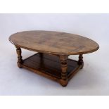 A 20th century oak oval coffee table on turned supports, 130 x 76 cm