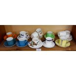 A collection of twelve decorative coffee cans and saucers