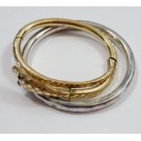 A gold plated snake bangle and a white metal bangle