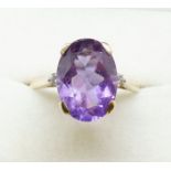 A 9ct gold amethyst ring flanked by two small diamonds, size T