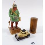 A Pretel carving of a fisherman, a Mauchline pot decorated Norwich Cathedral and a Matchbox car