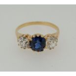 An 18 carat gold ring set sapphire flanked by two diamonds, size M to N - unmarked