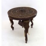 An Indian table with three carved elephant supports with bone tusks