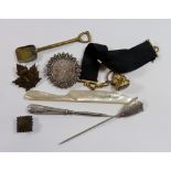 An Edwardian silver brooch and stick pin both unmarked, a gold plated fob, two military badges etc.