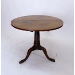 A Georgian oak tilt top wine table on turned column and triple cabriole supports, 80 cm (diameter)