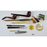 A small group of collectables including pipes, cigarette holder, a plug of tobacco, badges, a pipe