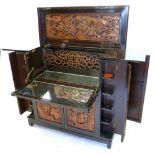 Chinese hardwood cocktail cabinet with elaborate panels of carved decoration, rise top over cupboard