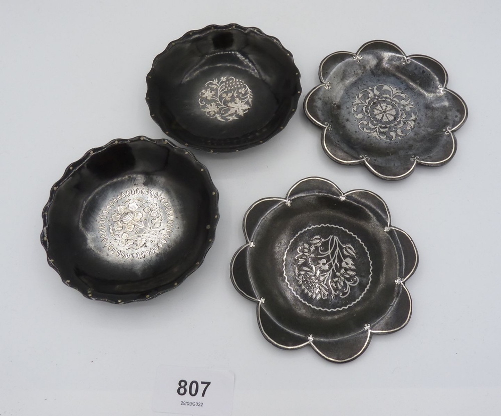 Four white metal inlaid pewter pin dishes with floral decoration, 9.5cm diameter