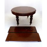 A Victorian mahogany oval dining table with two interleaves on carved supports and castors
