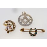 A 9 carat gold Edwardian horseshoe brooch, a masonic yellow metal brooch and a silver masonic