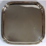 A square silver salver on scroll feet, 717g, London 1934