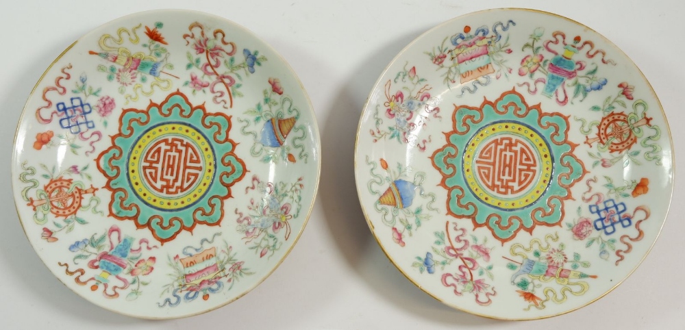 A pair of Chinese Kang Xi saucers paitned Babao and Shou symbols with 'Da Qing Guang Xu Nian Zhi