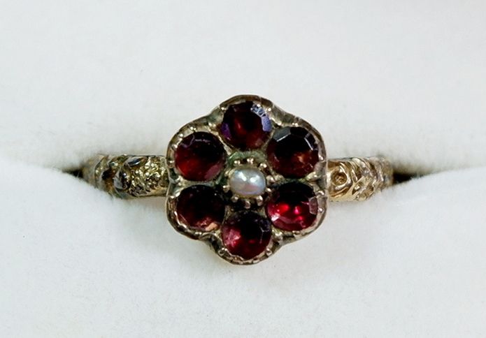 A Victorian yellow metal ring of flower form set amethyst and seed pearl, the shank with floral cast