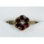 A Victorian yellow metal ring of flower form set amethyst and seed pearl, the shank with floral cast