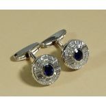 A pair of 18 carat white gold sapphire and diamond cufflinks, the central oval cut sapphire within