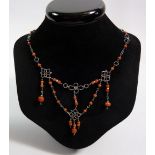 A silver Arts & Crafts white metal necklace with coral beads and decorative links