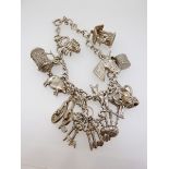 A silver charm bracelet and silver and white metal charms, 42g
