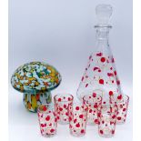 A vintage glass decanter and six liqueur glasses with polka dot decoration and a glass paperweight