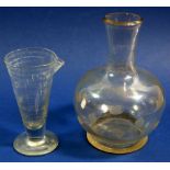 A glass medicine measure and a glass carafe