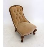 A Victorian rosewood framed nursing chair with floral carved rail and button upholstered back