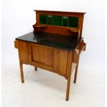 An Edwardian satin walnut washstand with marble top and green Aesthetic Movement style tile back