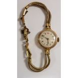 An early 20th century 9 carat gold ladies wrist watch and gold plated strap