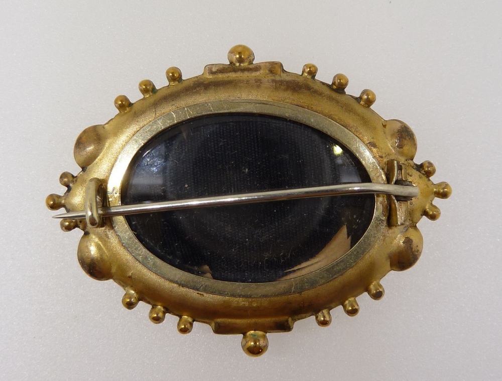 A Victorian yellow metal fronted oval brooch with embossed decoration and set chip diamond - Image 2 of 2