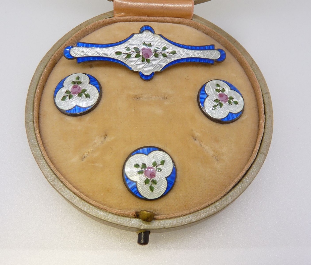 A silver and enamel floral brooch and three matching buttons boxed, Birmingham 1913 by J Aitkin &