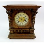 A Victorian wooden mantel clock with spindle decoration, 29cm tall