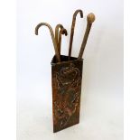 An Arts and Crafts copper triangular stick stand embossed lizard, 59cm tall including walking sticks