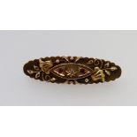A Victorian 9 carat gold oval brooch with scrollwork decoration set chip diamond and red stones, 3.7