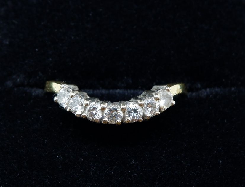 An 18 carat gold ring set curve of seven diamonds, size M