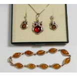 A silver owl necklace and earrings set and a silver and amber bracelet