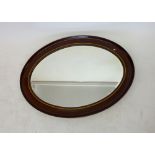 A large oval mahogany framed mirror with satinwood inlay, 89 x 65cm