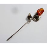 A vintage white metal and amber rose form stick pin