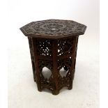 A small Indian carved hardwood small octagonal occasional table, 33cm tall